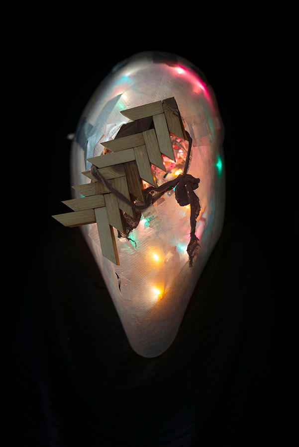 A colorfully lighted egg form, emerging from a black background.