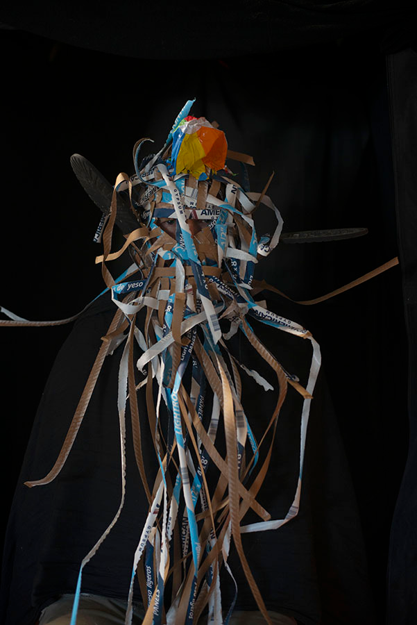 A mask consisting of a tangle of paper strips.