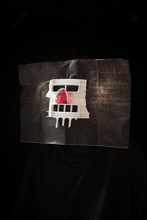 A white plastic mask that looks similar to a skull on a black field.